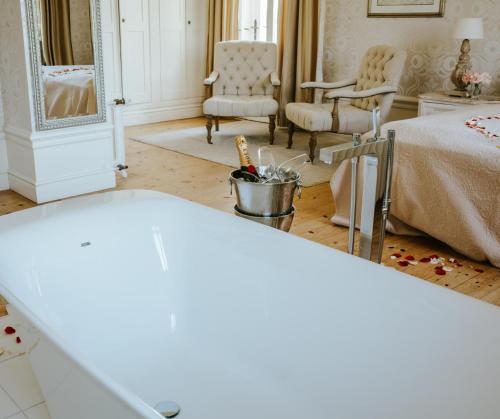 a room with a bed and two chairs at Schloss Krugsdorf Golf & Hotel in Krugsdorf