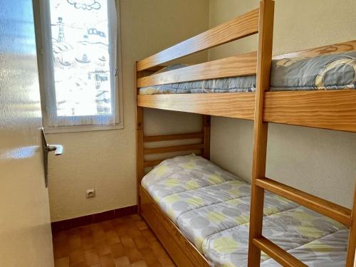 une chambre avec deux lits superposés et une fenêtre dans l'établissement Appartement Studio cabine 4 couchages ARGELES SUR MER AR020-012, à Argelès-sur-Mer