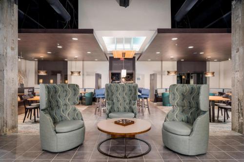 a lobby with two chairs and a table and some tables at Courtyard by Marriott Niagara Falls, USA in Niagara Falls