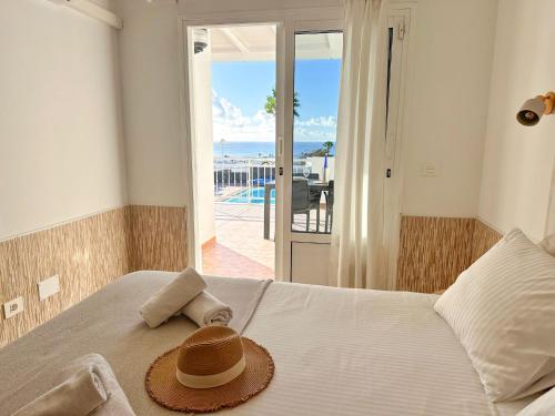 einen Hut auf einem Bett mit Meerblick in der Unterkunft Villa Siempre Mar in Puerto del Carmen