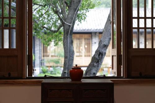 a vase sitting on a table in front of a window at the Wild Luxury Holiday Inn in Xingping