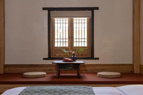 a room with a bed and a table with a window at the Wild Luxury Holiday Inn in Xingping