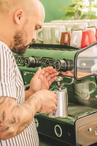 a man is using a coffee machine at Khiwane Boutique Hotel in Hoedspruit