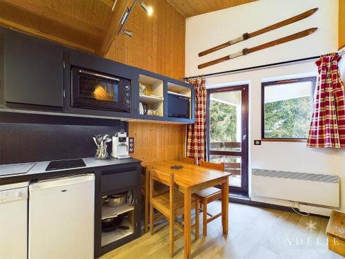 une cuisine avec une table en bois et un micro-ondes dans l'établissement Studio mezzanine cosy, 4/5 pers, à 80m des pistes, balcon, TV/DVD, kichenette équipée - FR-1-398-553, à La Rosière