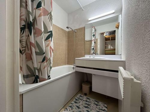 une salle de bain avec une baignoire, un lavabo et un miroir dans l'établissement Studio en RdC avec terrasse, jardin et parking, Montgenèvre - FR-1-330D-58, à Montgenèvre