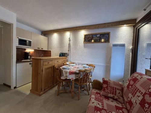 une cuisine avec une table et une cuisine avec une table et des chaises dans l'établissement Studio en RdC avec terrasse, jardin et parking, Montgenèvre - FR-1-330D-58, à Montgenèvre