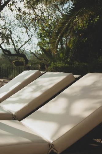 a row of white benches with trees in the background at Finca Can Estades in Calvia Town