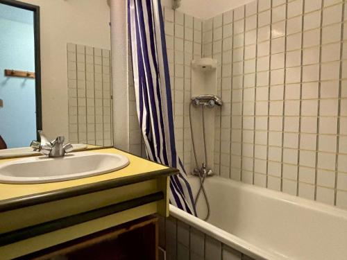 une salle de bain avec un lavabo et un rideau de douche dans l'établissement Appartement 2 pièces cabine 4 couchages ARGELES SUR MER AR260-211, à Argelès-sur-Mer