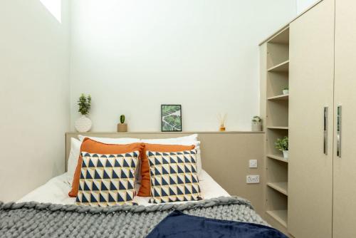 a bedroom with a bed with orange and blue pillows at HFS Redvers Towers Sheffield in Sheffield