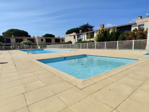 une grande piscine dans un patio avec une clôture dans l'établissement Studio 4 couchages ARGELES SUR MER AR590-018, à Argelès-sur-Mer