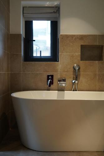 a bath tub in a bathroom with a window at the Wild Luxury Holiday Inn in Xingping