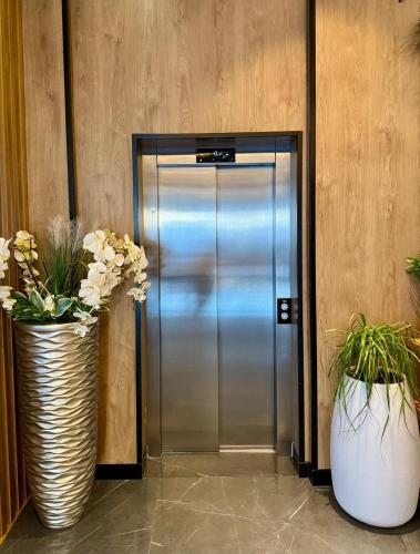 a metal elevator with two vases with flowers in it at Henry Resort & Spa in Golem