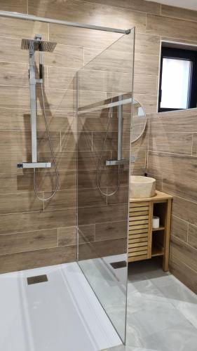une douche avec une porte vitrée dans une salle de bain dans l'établissement Les Logis du Sud - Pampa et Olivier, à Gallargues-le-Montueux