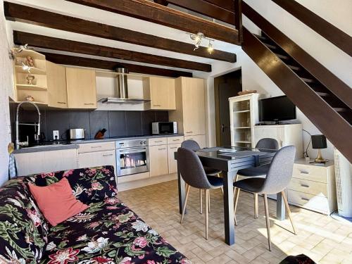 un salon avec une table et des chaises et une cuisine dans l'établissement Maison 2 pièces mezzanine 5 couchages ARGELES SUR MER AR610-074, à Argelès-sur-Mer