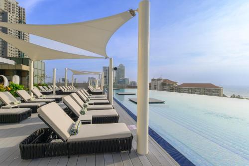 a swimming pool with lounge chairs on the roof of a building at Cinnamon Life at City of Dreams in Colombo
