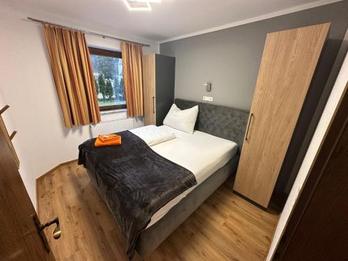 a bedroom with a bed and a window at Appartementhaus Hüttenberger in Erpfendorf