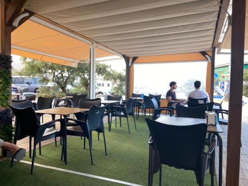 restauracja ze stołami i krzesłami oraz ludzie siedzący przy stołach w obiekcie Apartamento Mar y Montaña w mieście Los Silos