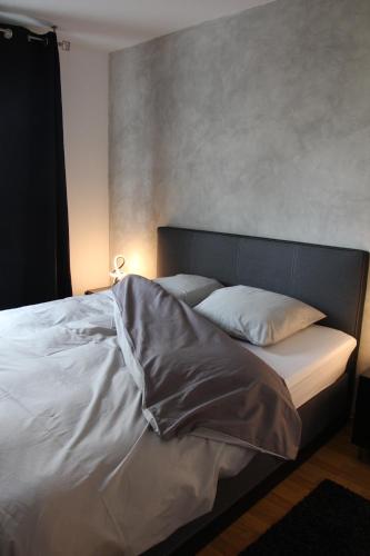 Elle comprend un grand lit avec des draps et des oreillers blancs. dans l'établissement Appartement, à Saint-Louis