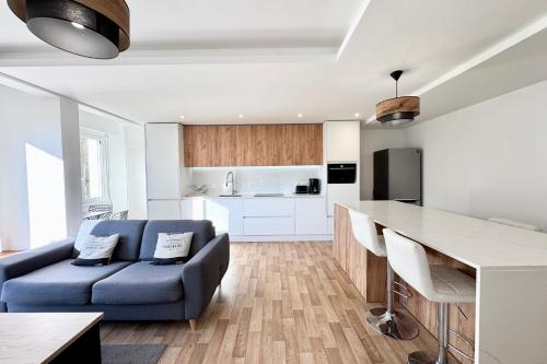 un salon avec un canapé bleu et une cuisine dans l'établissement T3 Top Cosy - Face à la mer, à Ploemeur