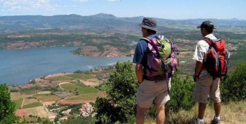 two men standing on top of a hill looking at a lake at Chez Providence Chambres et Table d'Hôtes in Cuxac-Cabardès