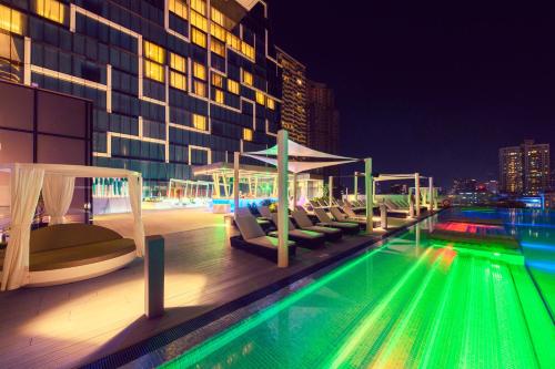 a pool with lounge chairs and a building at night at Cinnamon Life at City of Dreams in Colombo
