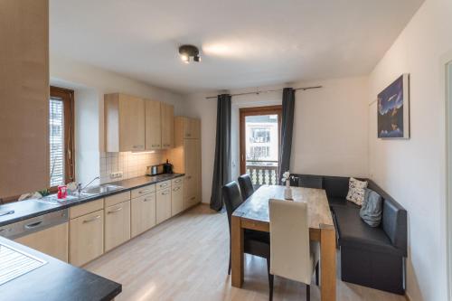 a kitchen and dining room with a table and chairs at Ski-n-Lake City Apartments in Zell am See