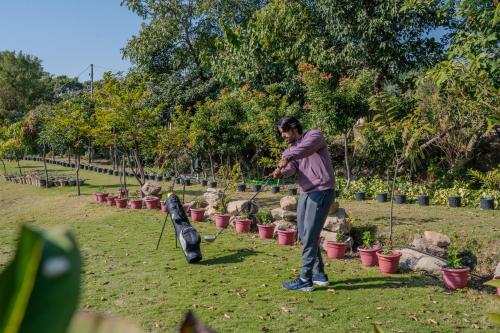 a man playing with a dog in a garden at SaffronStays Timber Nest in Kandogal
