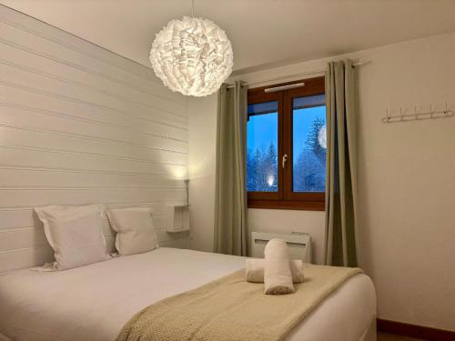 - une chambre avec un lit et un lustre dans l'établissement Capucins 3, à Chamonix-Mont-Blanc