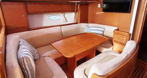 ein Wohnzimmer mit Tisch und Couch in der Unterkunft Cruzeiro de 7 Dias em Portugal a Bordo de um Veleiro in Figueira da Foz