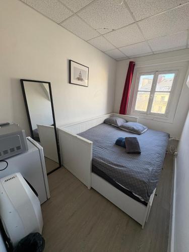une petite chambre avec un lit et un miroir dans l'établissement Cozy Room Nearby Champs Elysées 6, à Paris