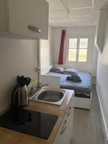 une petite cuisine avec un évier et un lit dans l'établissement Cozy Room Nearby Champs Elysées 6, à Paris