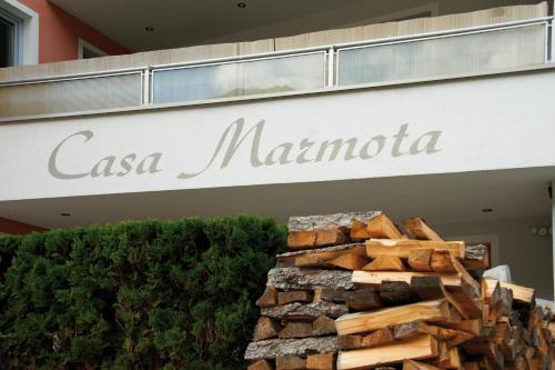 a pile of fire wood in front of a casa marina sign at Casa Marmota in Ischgl