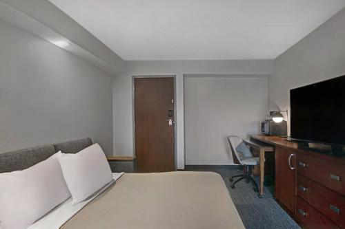 a hotel room with a bed and a flat screen tv at Courtyard Chicago Elmhurst/Oakbrook Area in Elmhurst