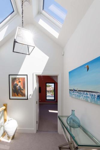 a living room with a glass table and windows at Luxury designer coastal home for 10 with hot tub in West Wittering
