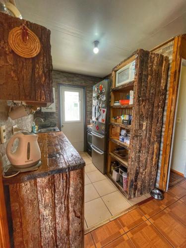 a kitchen with a wooden counter and a refrigerator at Casa Natales - Dormitorio Privado in Puerto Natales