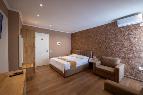 a bedroom with a bed and a chair in a room at Lider Hotel in Ksamil