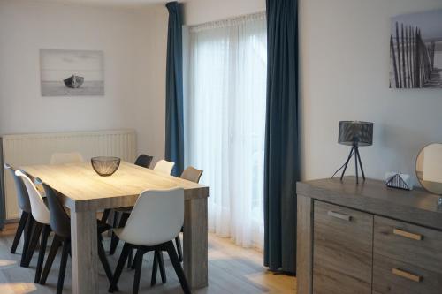 a dining room with a wooden table and chairs at Kustverhuur, Park Scheldeveste, Zwin 116 in Breskens