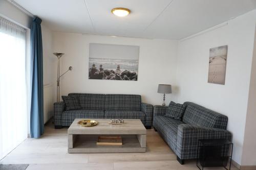 a living room with two couches and a coffee table at Kustverhuur, Park Scheldeveste, Zwin 116 in Breskens