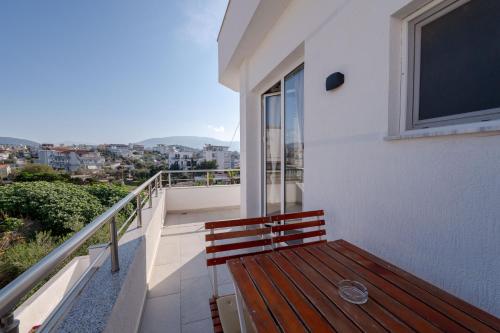 a wooden bench sitting on the balcony of a house at Lider Hotel in Ksamil