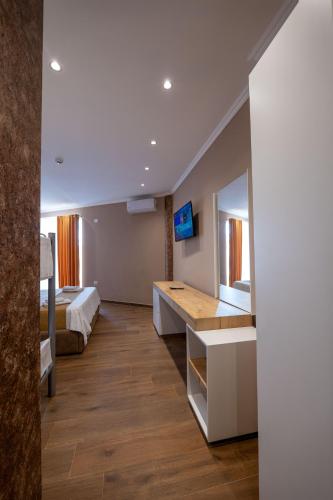 a hotel room with a bed and a desk with a mirror at Lider Hotel in Ksamil