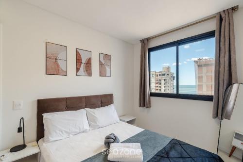 a bedroom with a bed and a large window at Apto c/ Vista Mar | 500m Praia Itapema DSH1702 in Meia Praia