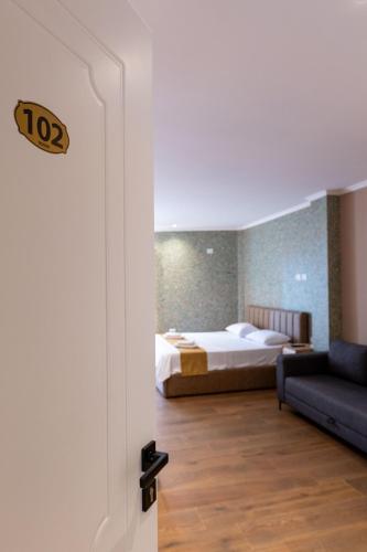 a bedroom with a bed and a couch in a room at Lider Hotel in Ksamil