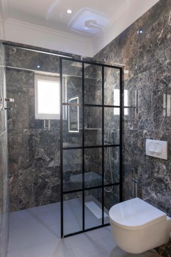 a bathroom with a glass shower with a toilet at Lider Hotel in Ksamil