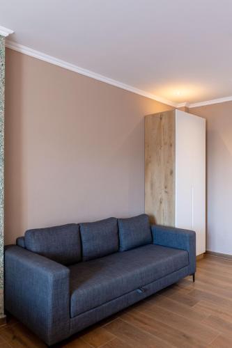 a blue couch in a room with a white wall at Lider Hotel in Ksamil