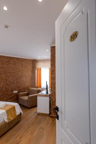 a bedroom with a bed and a living room at Lider Hotel in Ksamil