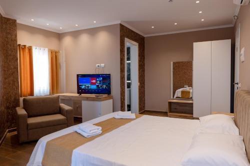 a hotel room with a bed and a television at Lider Hotel in Ksamil