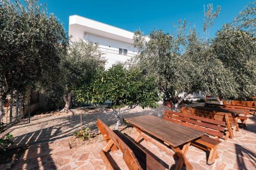 a group of wooden benches in front of a building at Lider Hotel in Ksamil