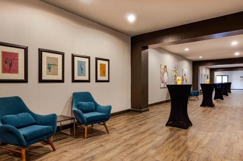 a waiting room with blue chairs and paintings on the wall at Hotel Preston Nashville Airport in Nashville