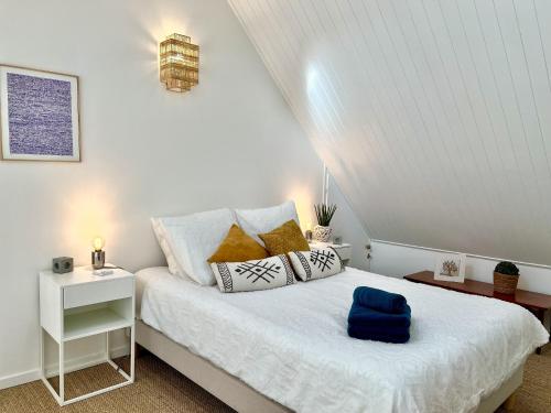 - une chambre avec un lit blanc et des oreillers dans l'établissement Duplex aperçu mer chaleureux 3 personnes, à Les Sables-dʼOlonne