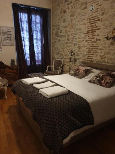 une chambre avec un grand lit avec des serviettes dessus dans l'établissement L'écu, à Saint-Amand-Montrond